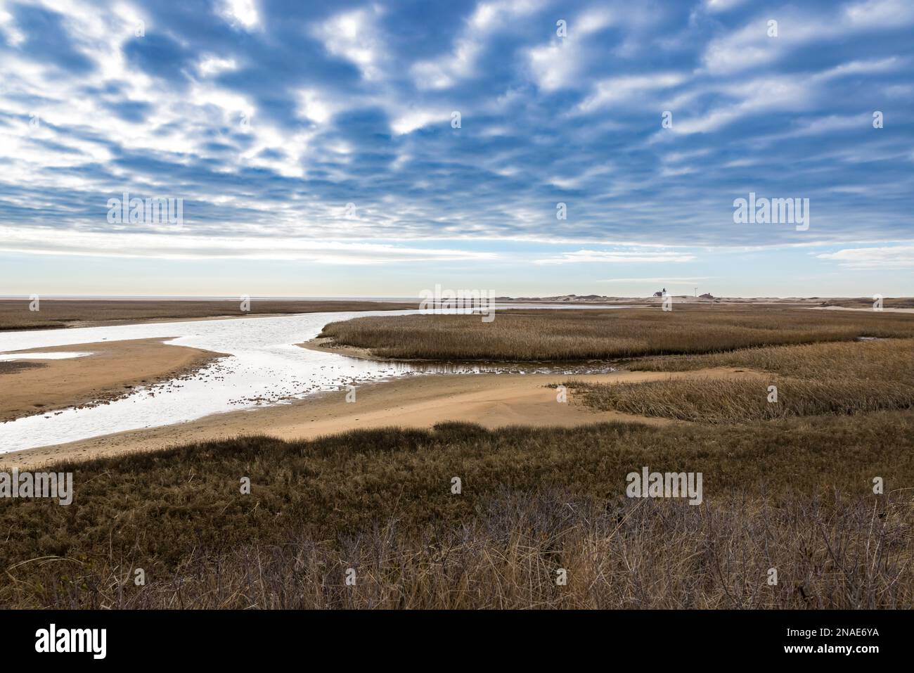 A view of marsh, river and dramatic clouds near Racepoint Lighthouse Stock Photo