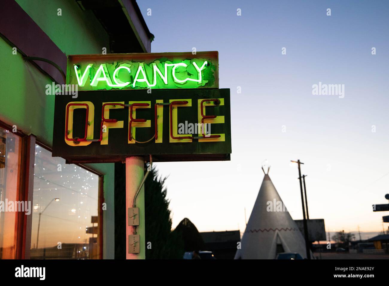glowing neon vacancy sign at the wigwam motel office at sunset Stock Photo