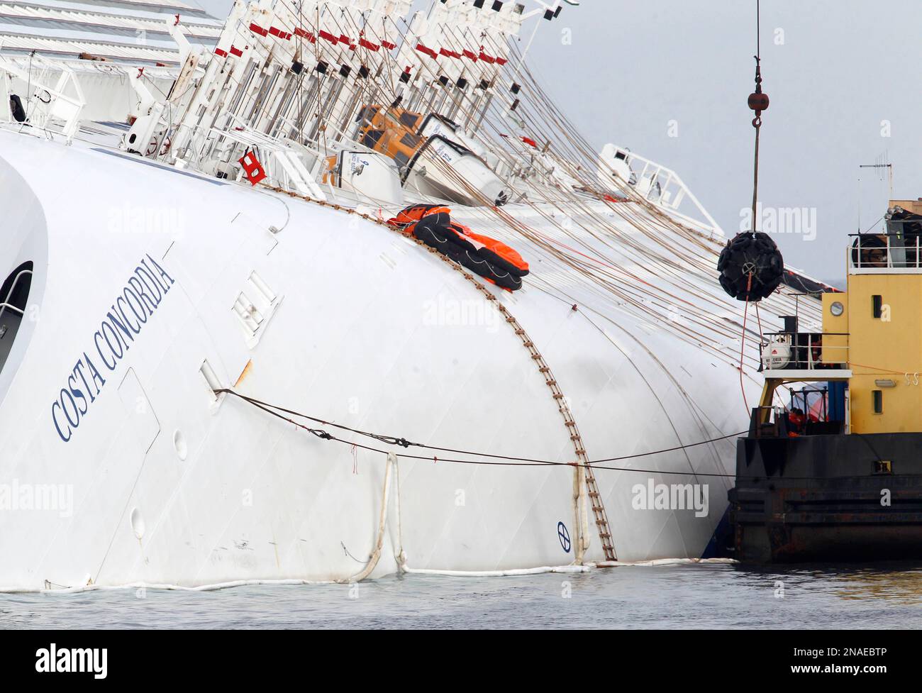 A Sea Platform Carrying A Crane Approaches The Grounded Cruise Ship a-sea-platform-carrying-a-crane-approaches-the-grounded-cruise-ship