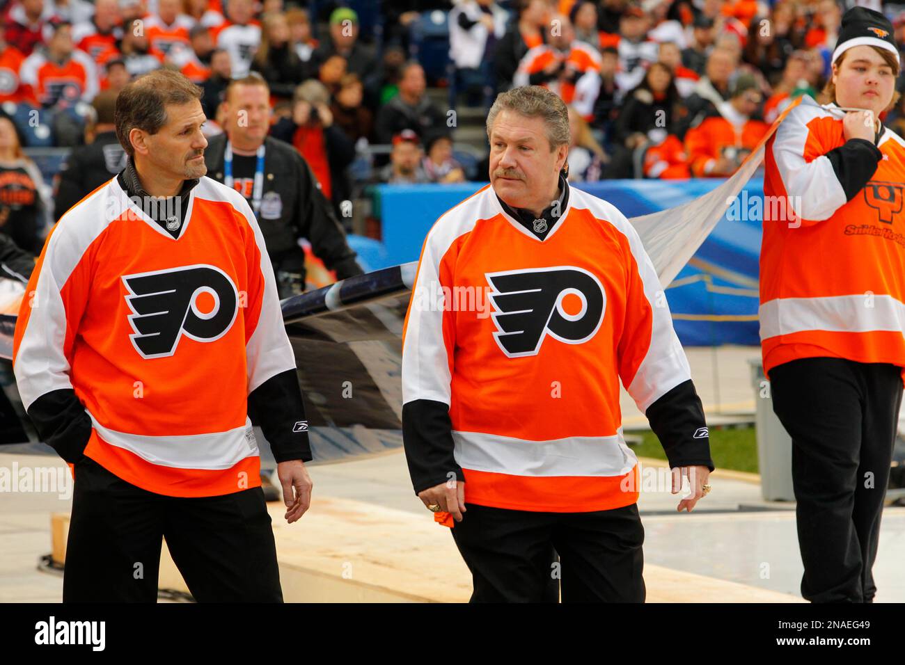 Ron Hextall, left, and Dave Schultz, right, of the Philadelphia Flyers  Alumni team walk to the rink during opening ceremonies for the Winter  Classic Alumni hockey game with the New York Rangers