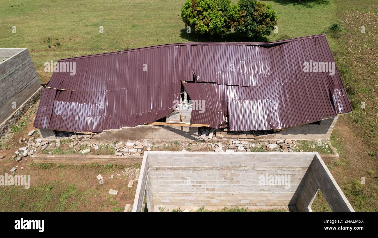 Building with a broken roof. Aerial view to destroyed house in natural disaster. Stock Photo