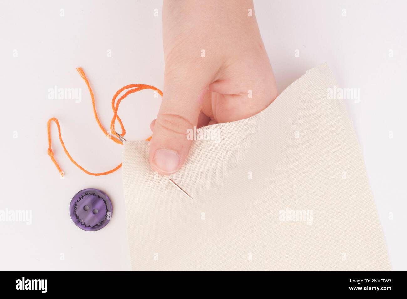 Child sewing on a button Stock Photo - Alamy