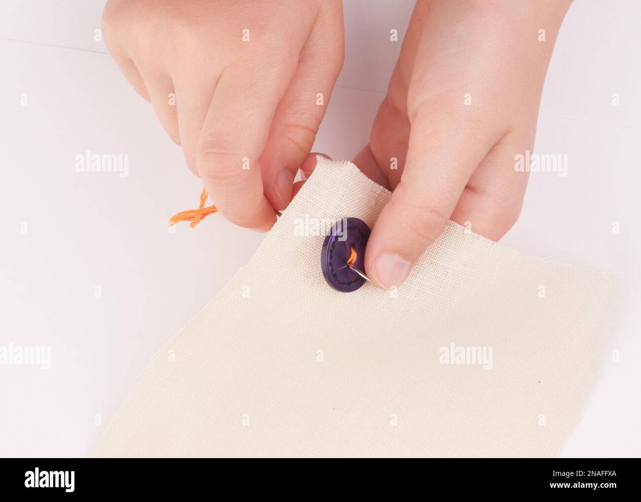 Sewing on a button Stock Photo - Alamy