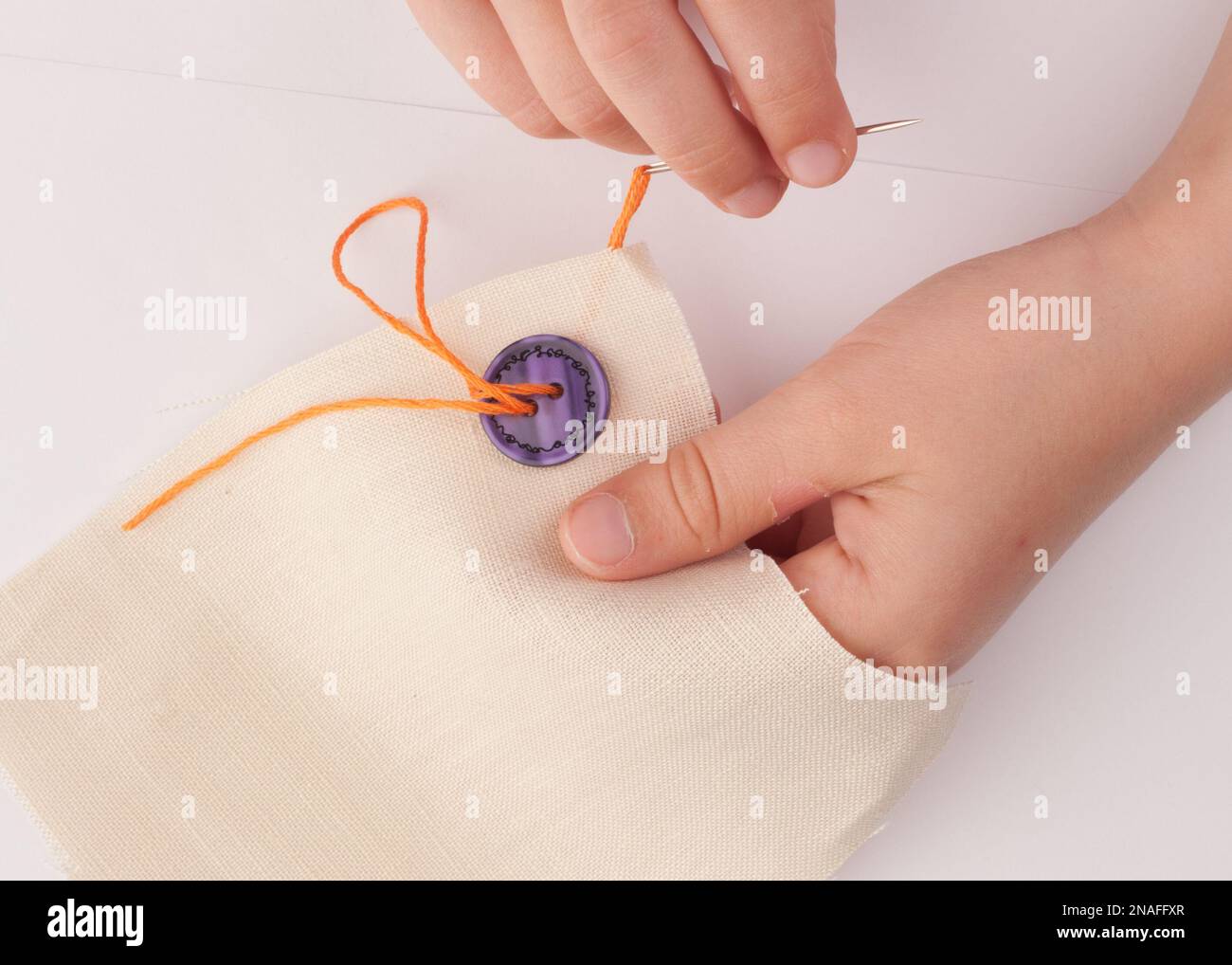 Sewing on a button Stock Photo - Alamy