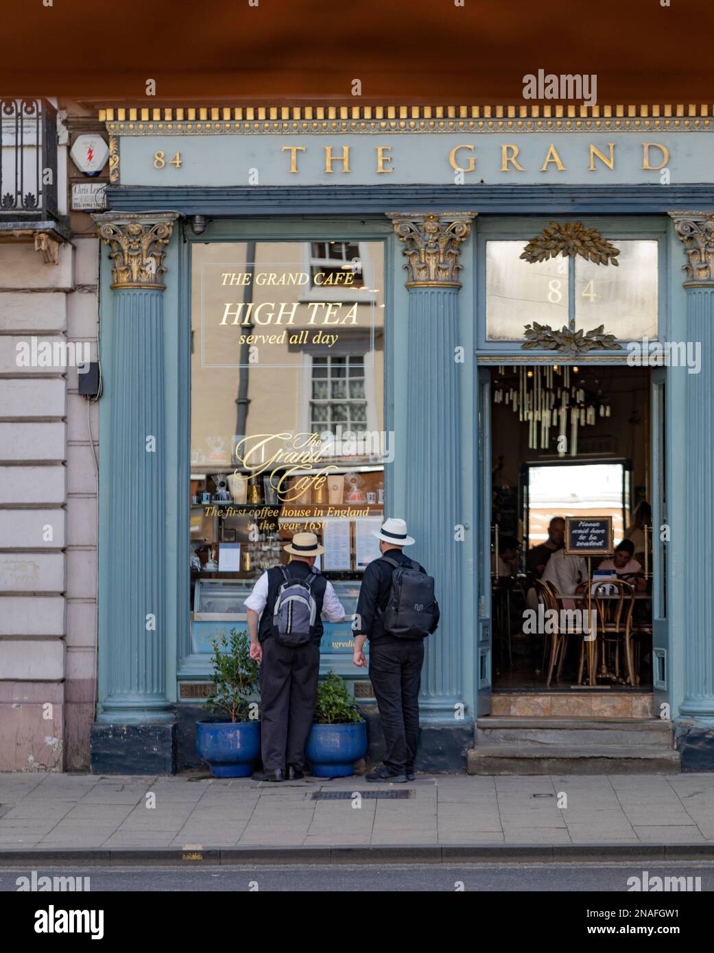 Men peering into the window of a cafe; Oxford, Englad Stock Photo