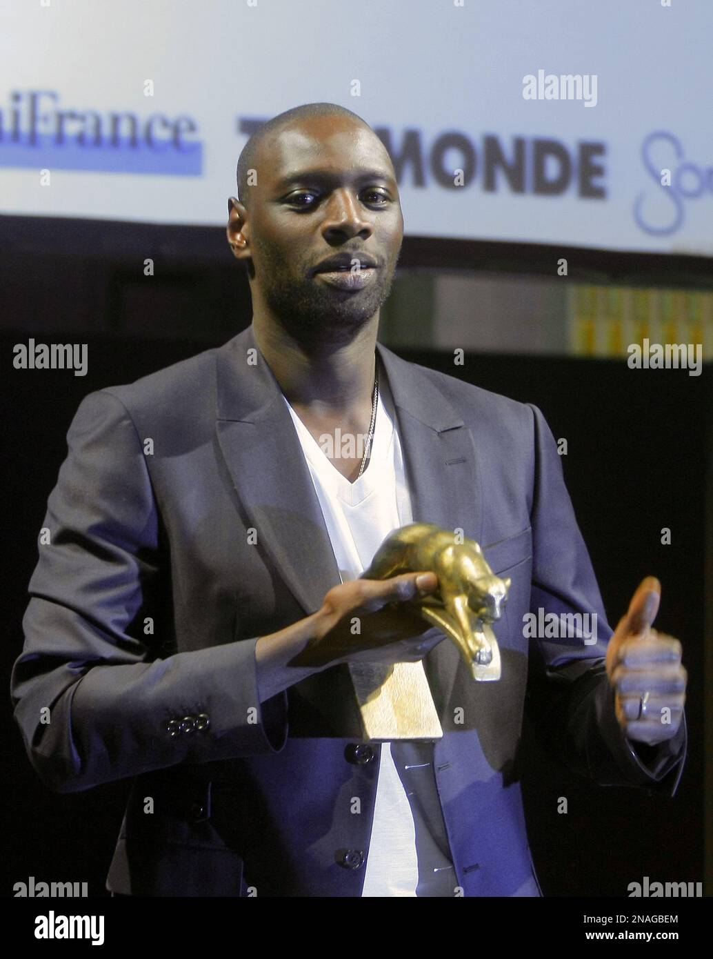 French Actor Omar Sy shows his trophy after being awarded with an Honor Panther for his best actor during the Prix Lumieres awards ceremony at Paris City Hall Friday Jan. 13, 2012. (AP Photo/Jacques Brinon) Stock Photo