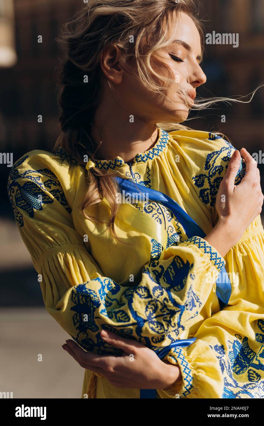 A young girl in an ethnic Ukrainian embroidered dress in the sun. independence Day. Yellow Ukrainian dress. Stock Photo