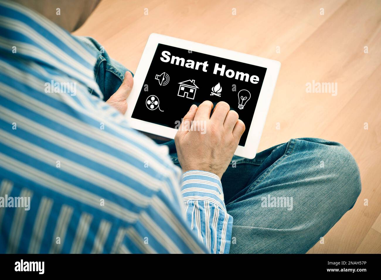 man holding a computer tablet with smart home controls on screen Stock Photo