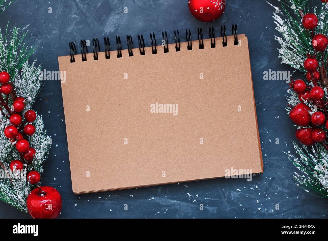 Notebook for records. A blank notebook page on a blue background next to Christmas branches and a Christmas ball. Christmas, New Year's concept. Top v Stock Photo