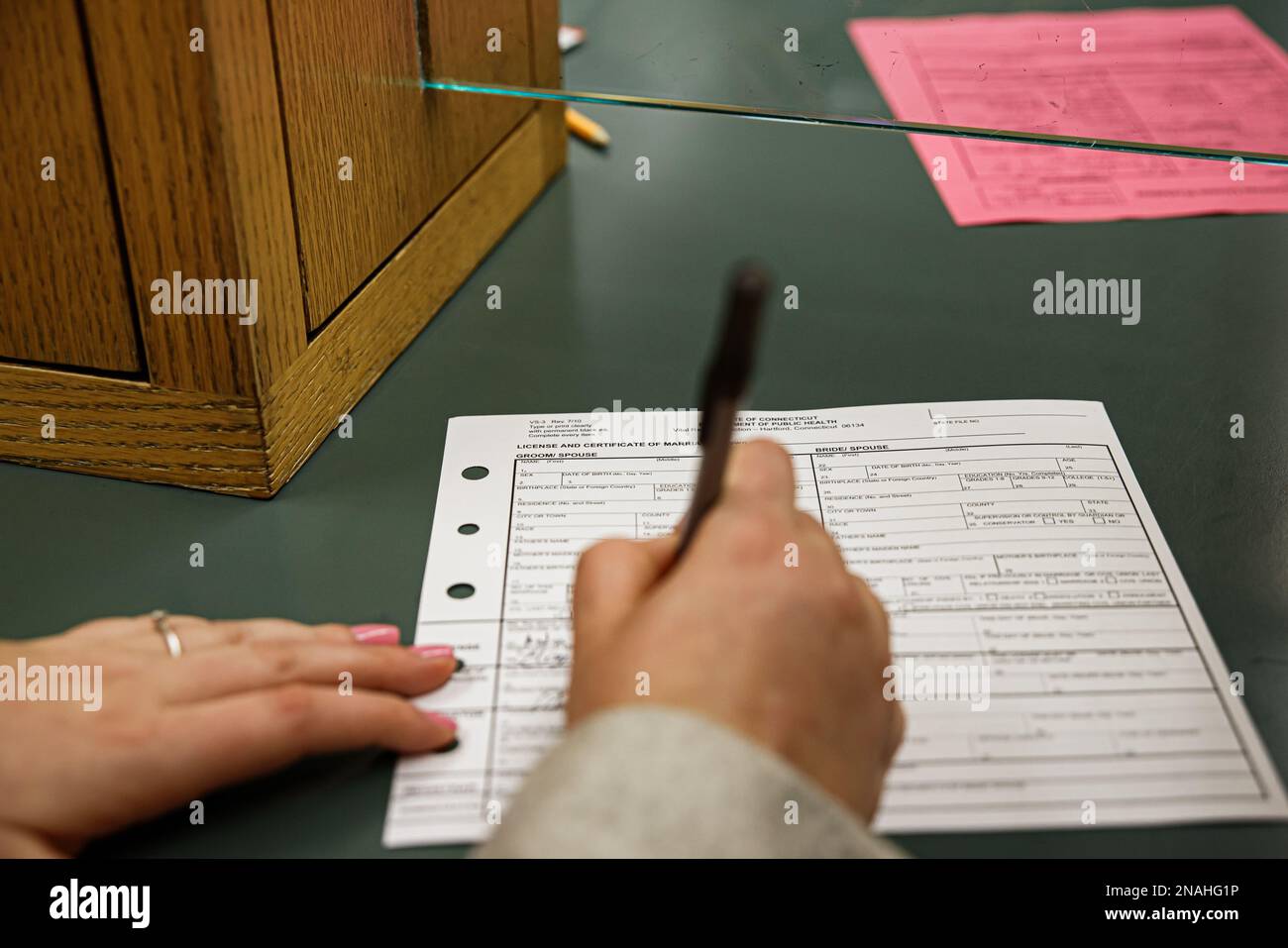 Bride and Groom signing marriage license certificate document at town