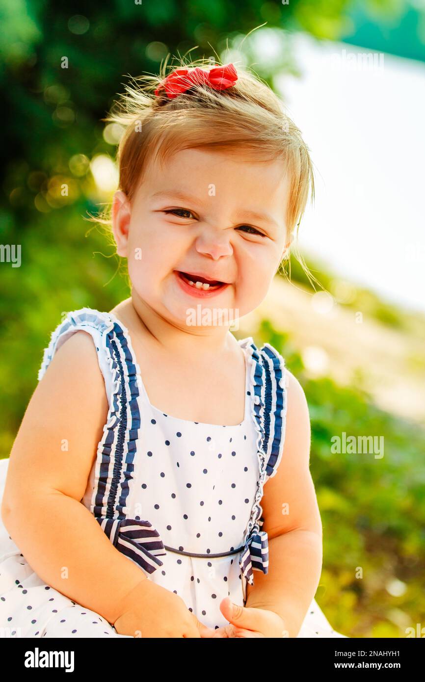 The little girl in the arms of mother smiling warmly. The baby