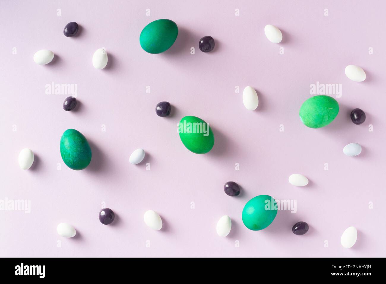 Green dyed easter eggs with purple and white candies on purple ...