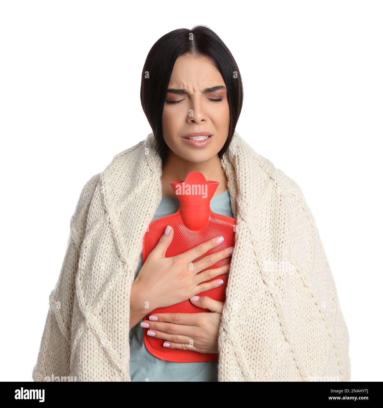 Woman using hot water bottle to relieve chest pain on white background