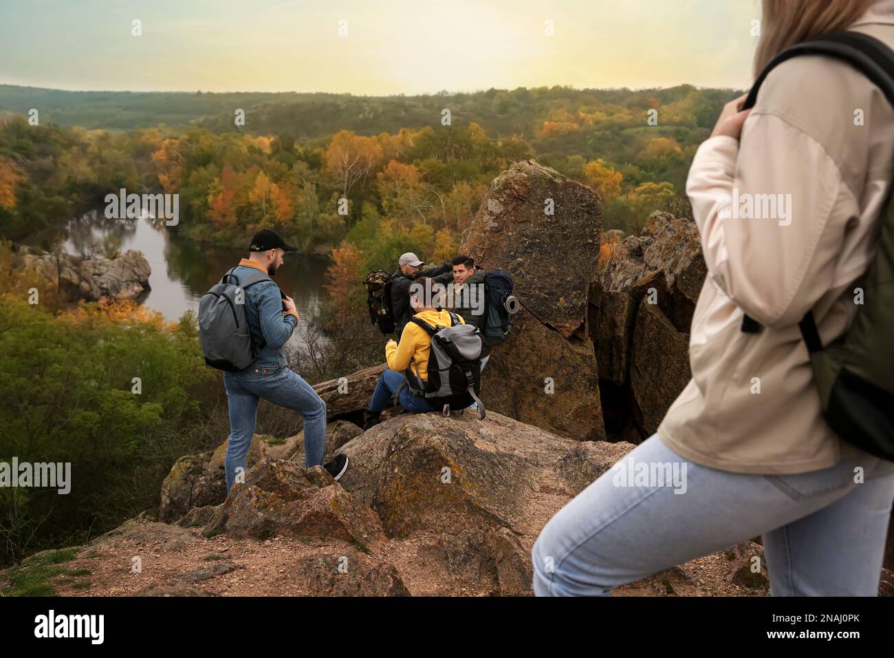 Group of hikers with backpacks climbing down mountain Stock Photo - Alamy