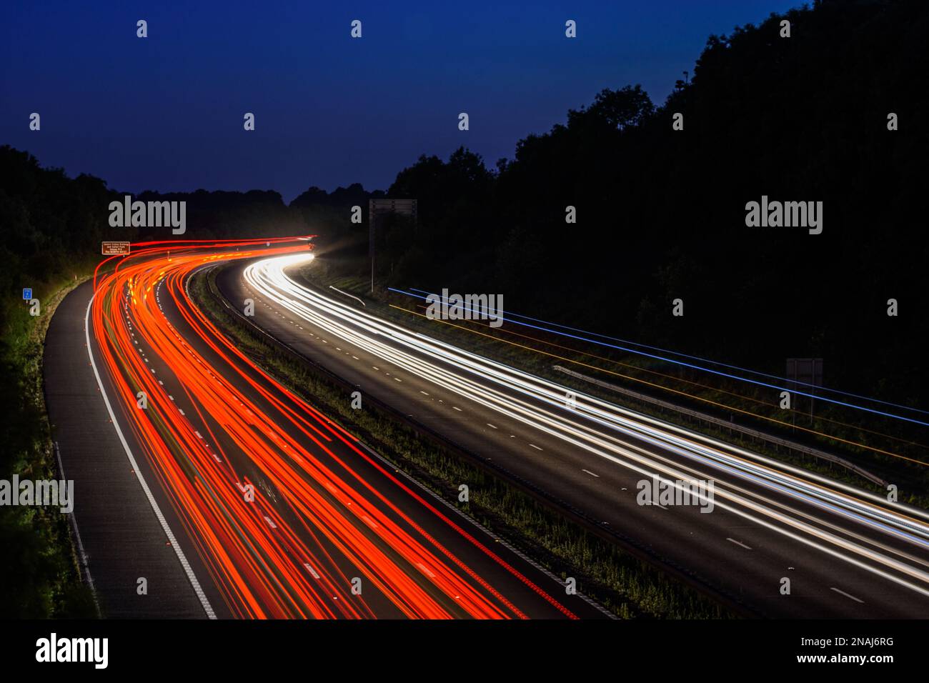 The fast moving cars on the M5 highway leave traffic light trails and ...