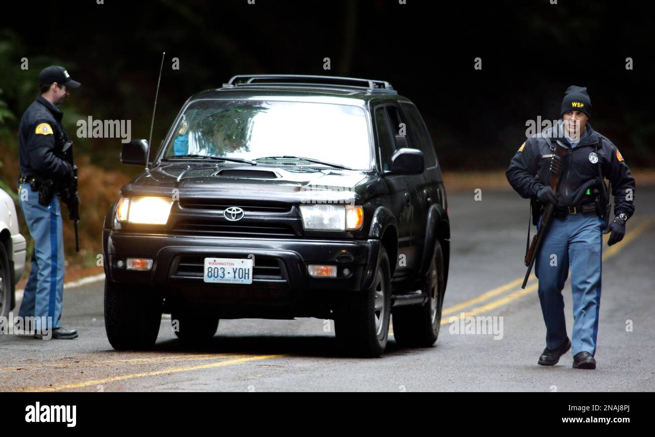 Washington State Patrol troopers carry guns as they check out a vehicle ...