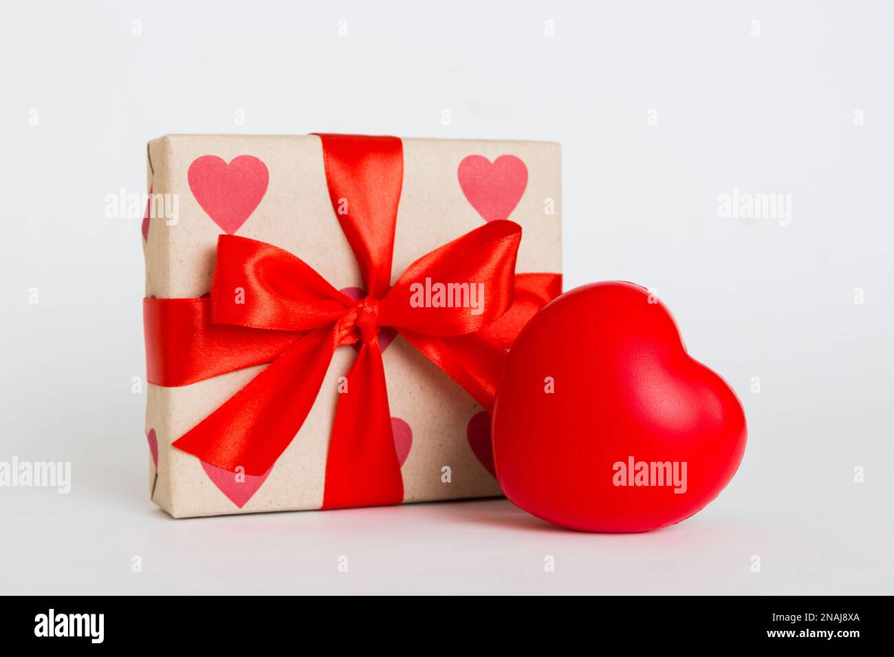 gift box with red bow and red heart on colored background. Perspective ...
