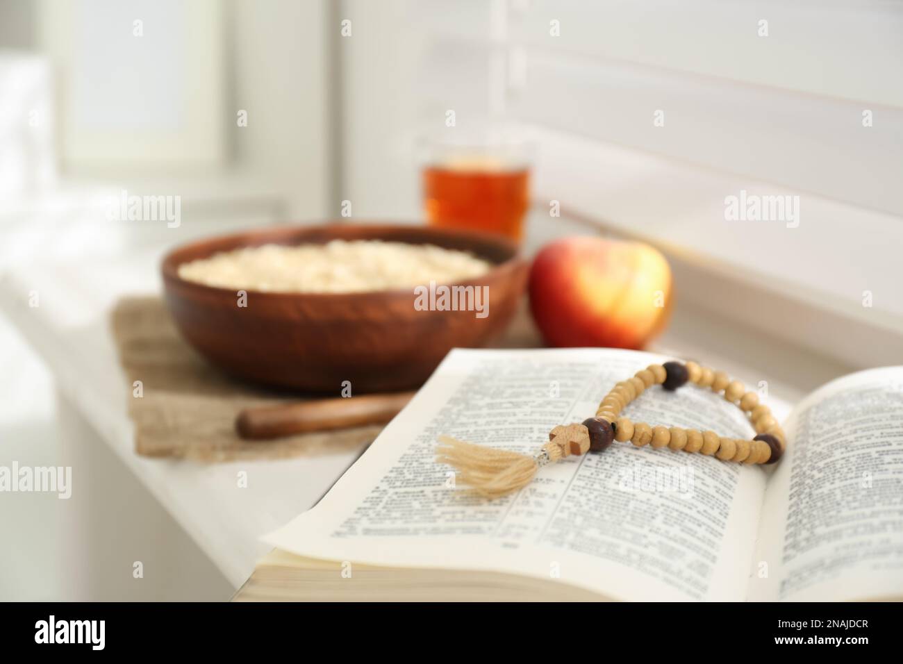 Holy Bible with prayer beads on window sill indoors, closeup. Great ...