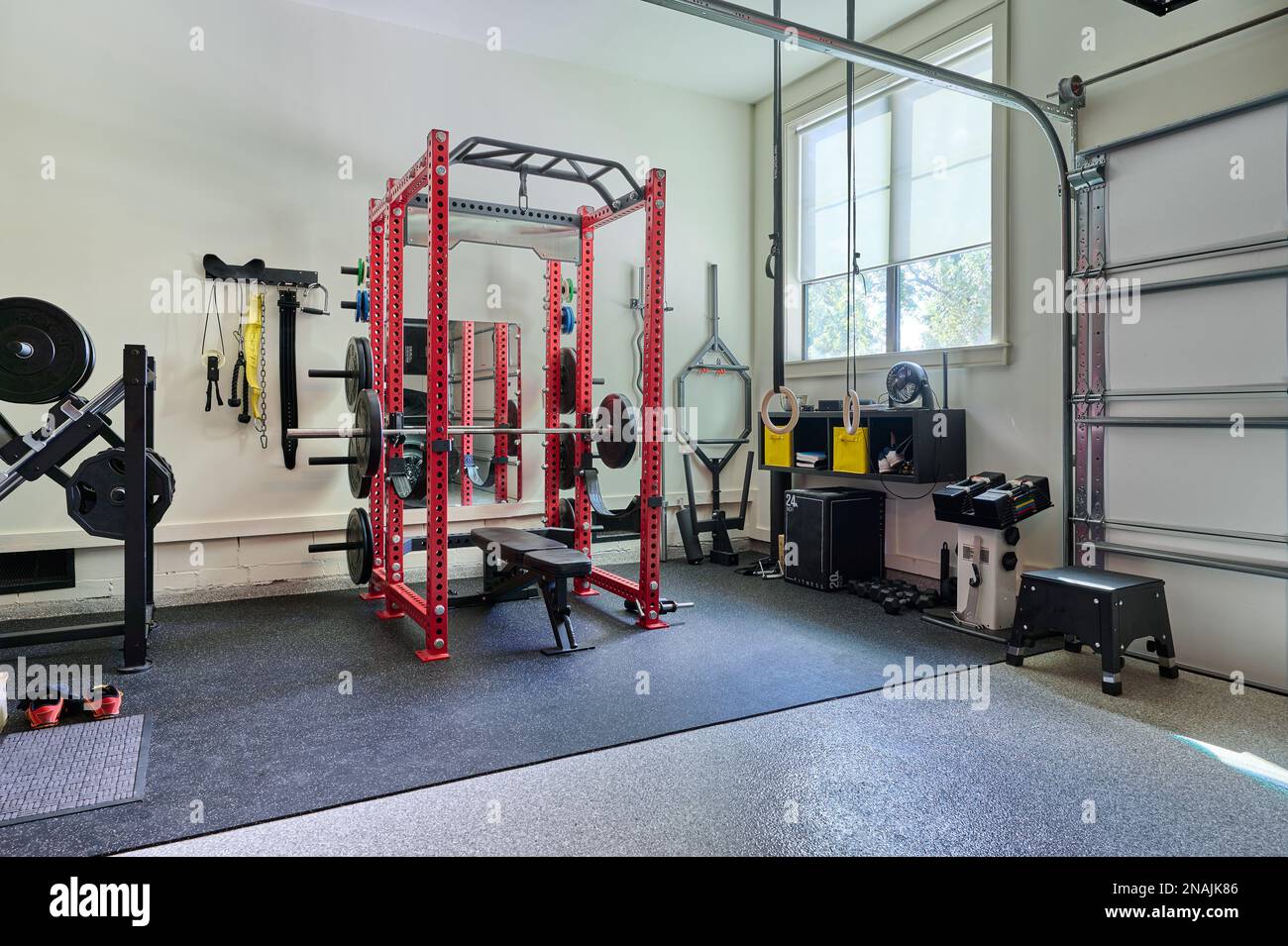 Squat Rack and Other Gym Equipment in Home Garage Gym for Weightlifting, Fitness, Exercise, Bodybuilding Stock Photo