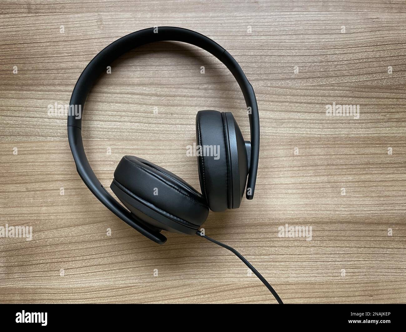 Headphones with an equalizer app open on a smartphone, showing frequency sliders