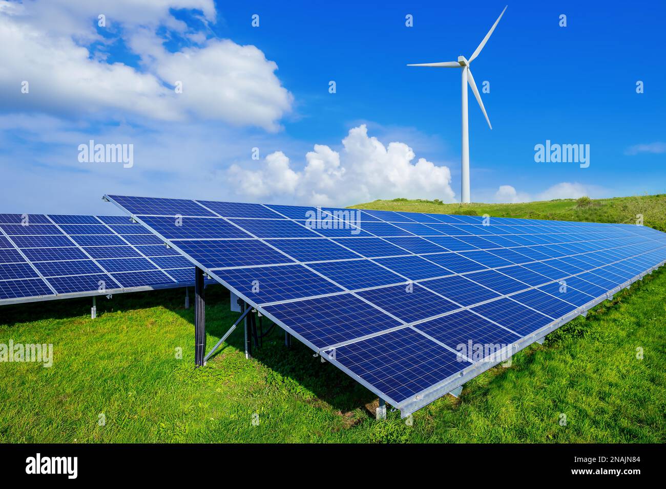 solar panels and a wind turbine against a blue sky Stock Photo - Alamy