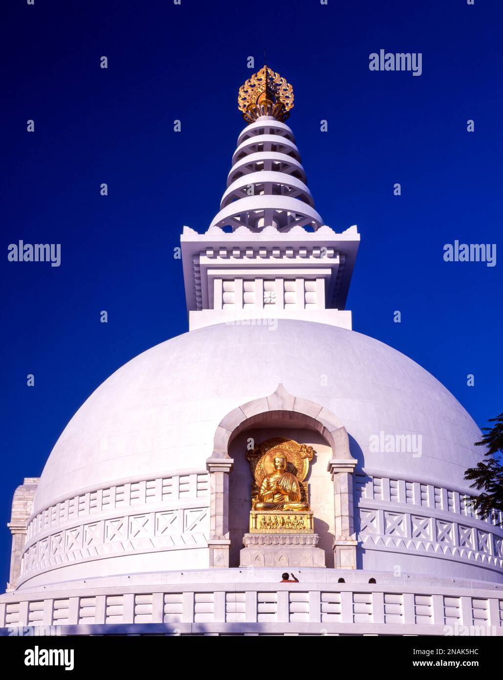 Stupa, golden seated Buddha as relief on a World Peace Stupa, Vulture Peak, Buddhist pilgrimage site at Ragir, Rajgir, Bihar, India Stock Photo