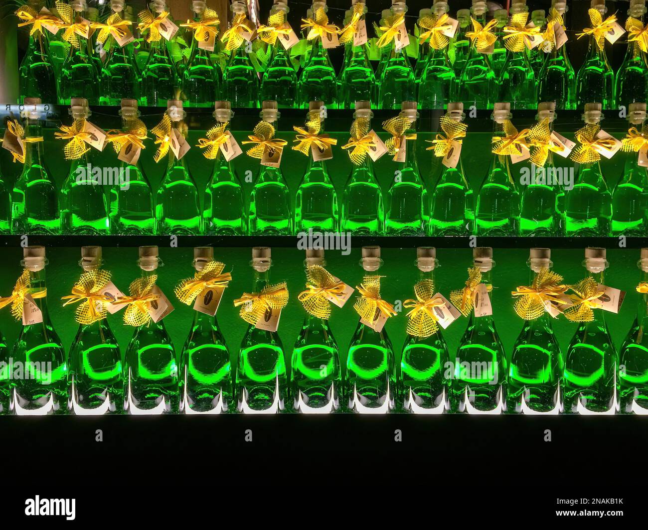 Three rows of bottles with alcoholic highproof drink green absinthe