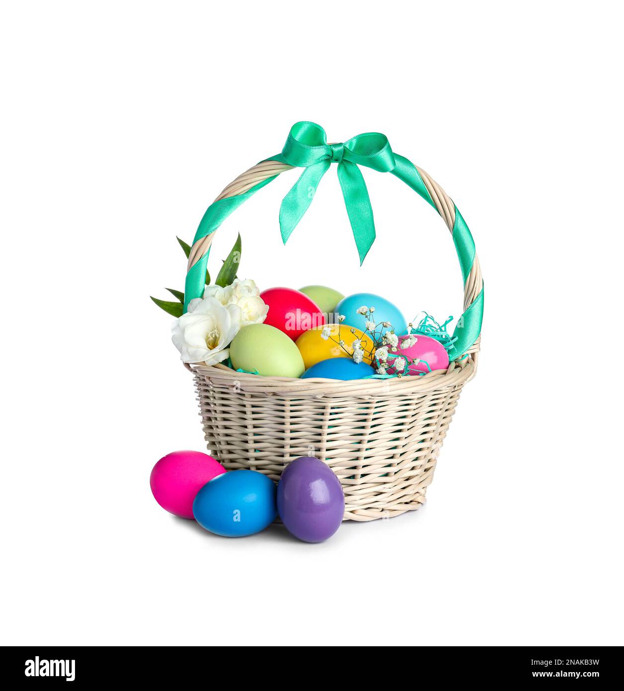 Wicker basket with bright painted Easter eggs and spring flowers on ...