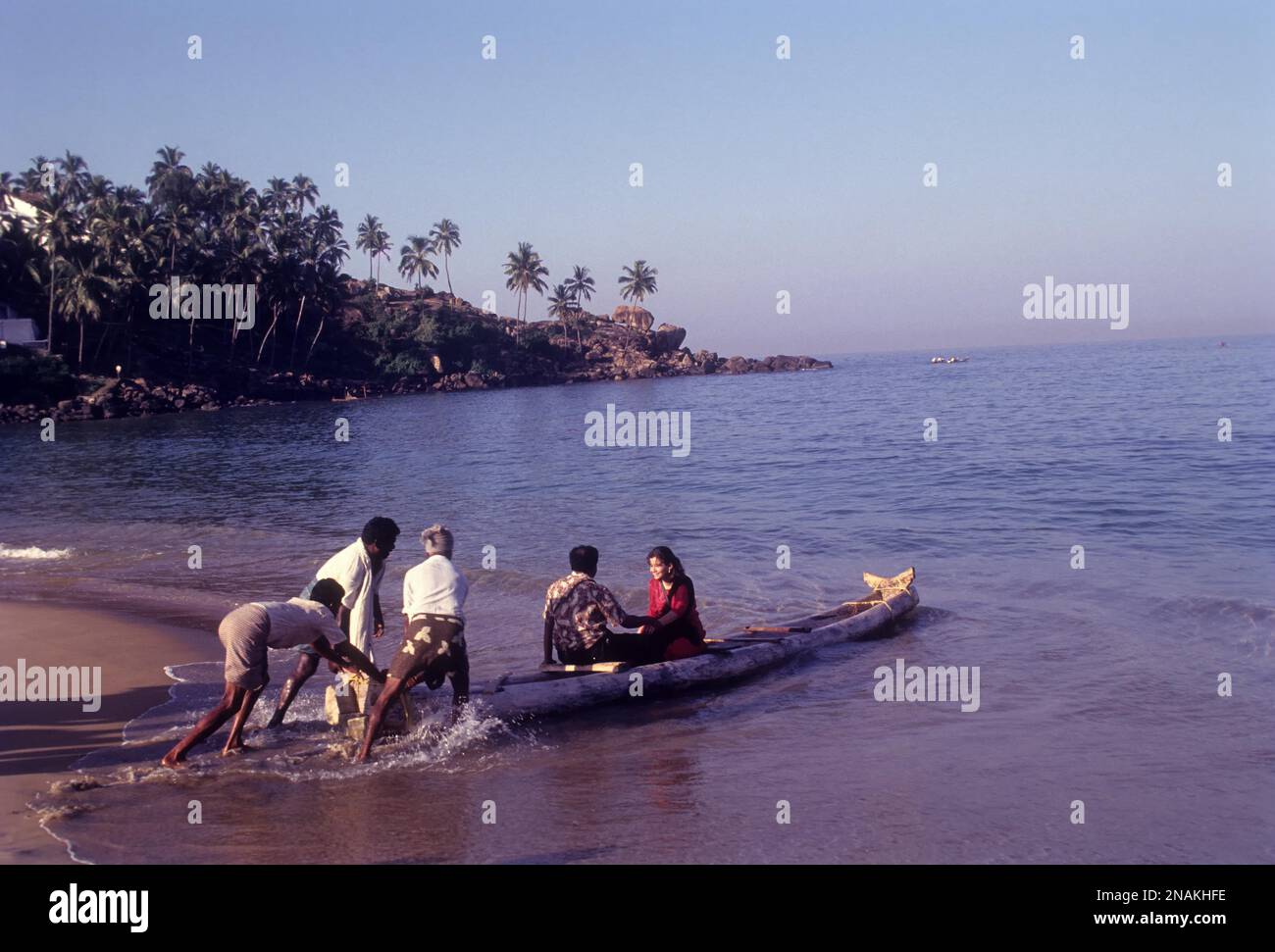 A couple enjoying a catamaran or kattumaram ride at Kovalam beach near Thiruvananthapuram, Kerala, India, Asia Stock Photo
