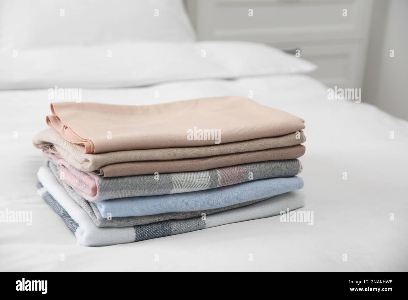 Stack of folded cashmere clothes on bed Stock Photo - Alamy