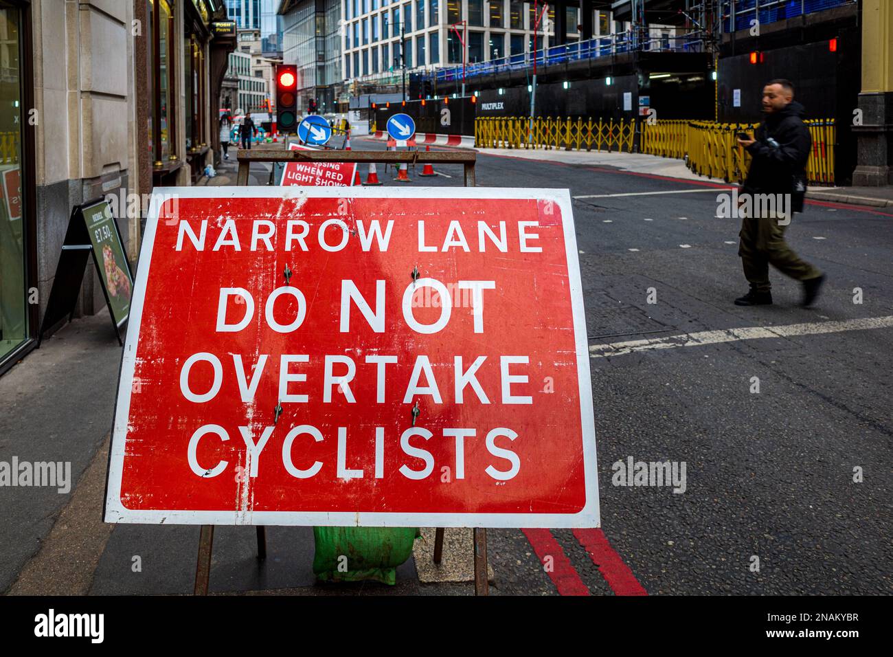 Do Not Overtake Cyclists Sign on a narrow lane in London. Narrow Lane Do Not Overtake Cyclists Sign in central London UK. Stock Photo