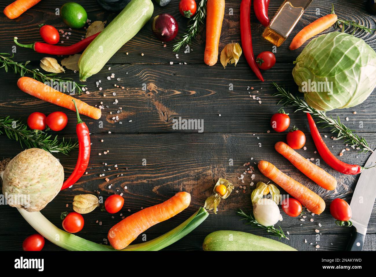 Assorted raw organic vegetables on dark wooden background with copy space. Food styling, culinary, healthy eating concept. Frame style, top view Stock Photo