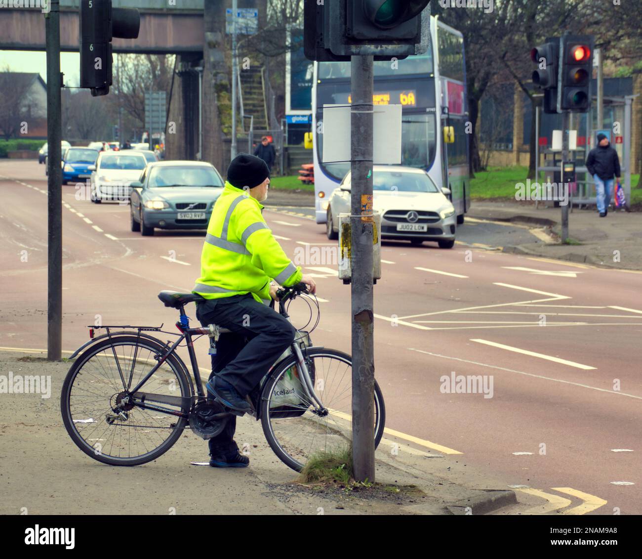 cyclist by traffic lights waiting to cross road Stock Photo