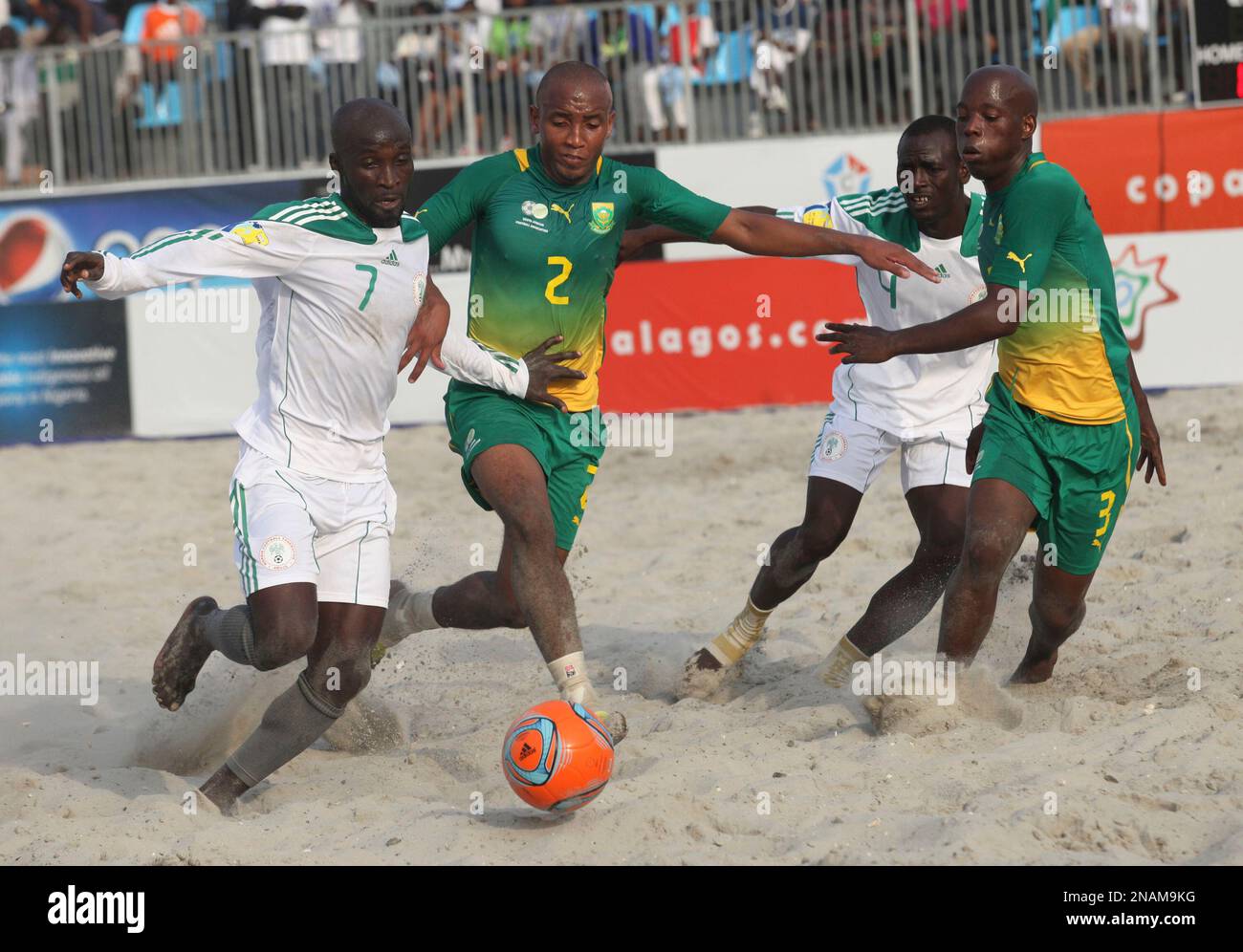 Nigeria's, Isiaka Oalawale, left, is challenged by South Africa's, Prince Gumede, centre, and Fani Shange, right, during a COPA Lagos beach soccer tournament at a beach in Lagos, Nigeria, Friday, Dec 16, 2011. (AP Photo/Sunday Alamba) Stock Photo