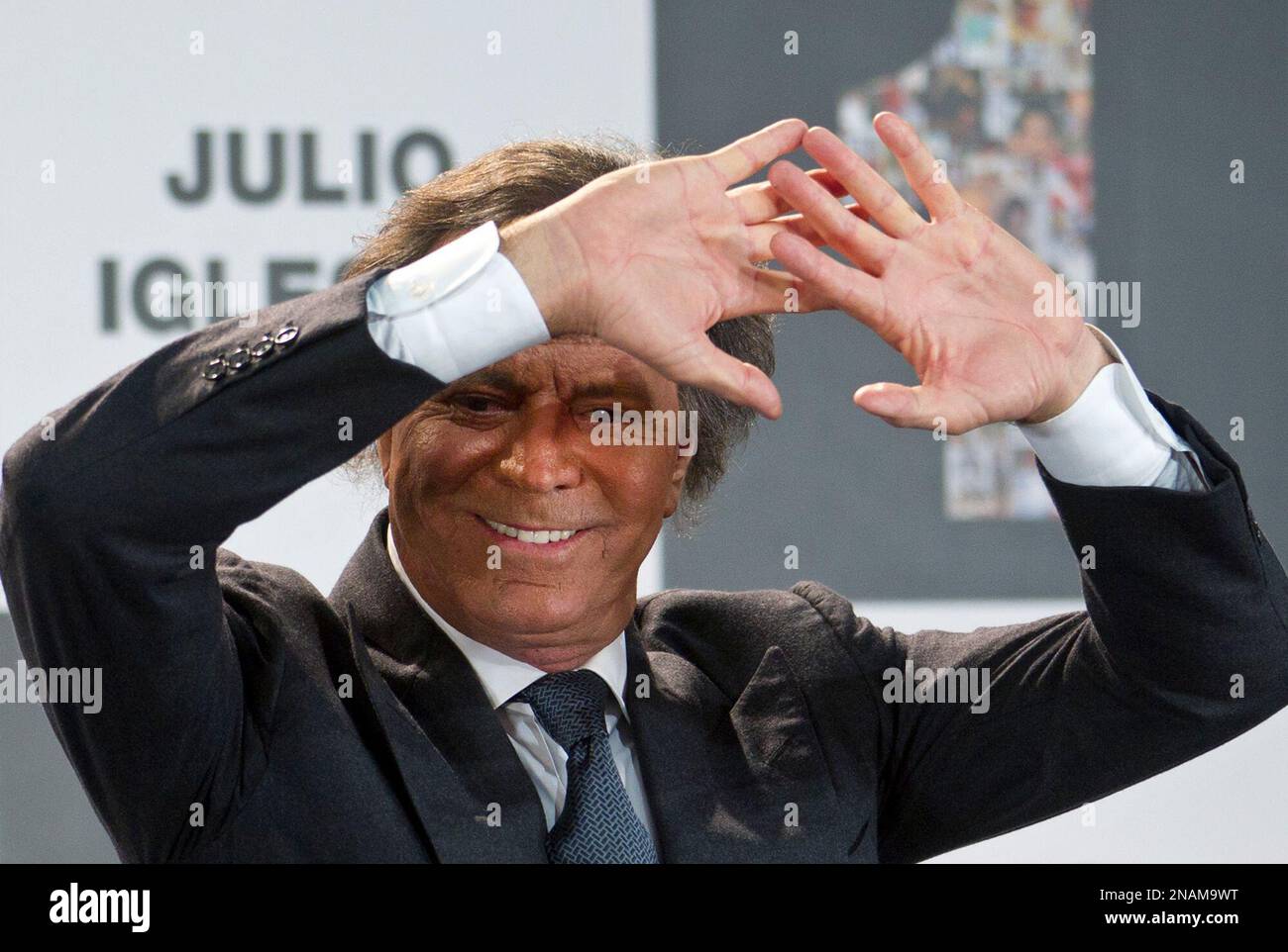 Spanish singer Julio Iglesias shields his eyes from the spotlights