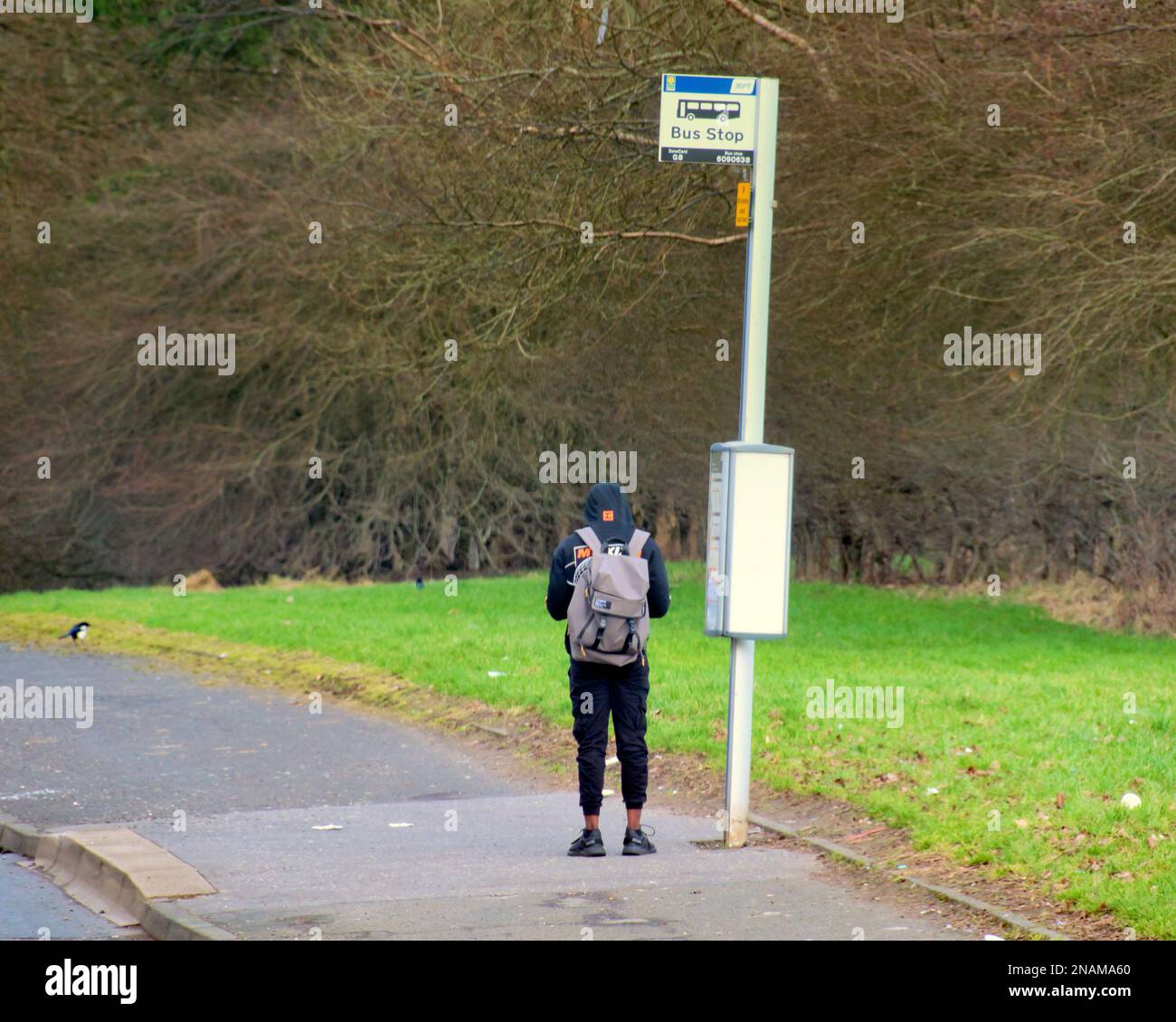 Grim Drumchapel housing estate poverty shots teenager at bus stop Stock Photo