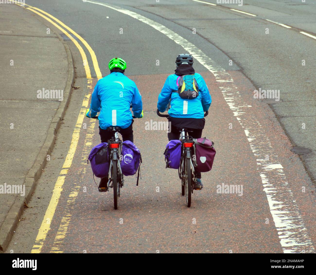 Couple cycling side by side on the road Stock Photo
