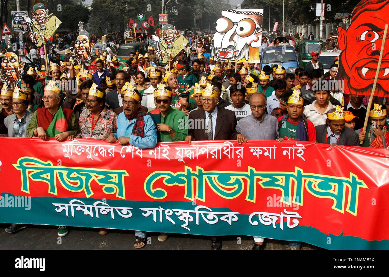 Bangladeshis carry a placard depicting war criminals during celebrations marking the 40th Victory Day anniversary in Dhaka, Bangladesh, Friday, Dec. 16, 2011. Victory Day, which commemorates the end of the Bangladesh liberation war against Pakistan, is celebrated each year on Dec. 16. Banner reads "No mercy for war criminals. Victory Day." (AP Photo/Pavel Rahman) Stock Photo