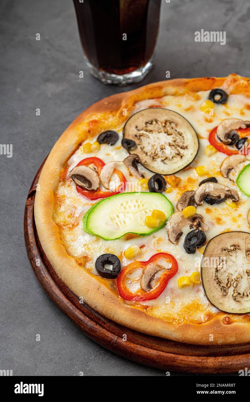 Vegetarian pizza with eggplant, zucchini and mushrooms on dark stone table Stock Photo