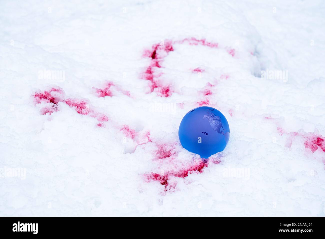 The concept of symbolism. crystal earth globe on snow with blood stains