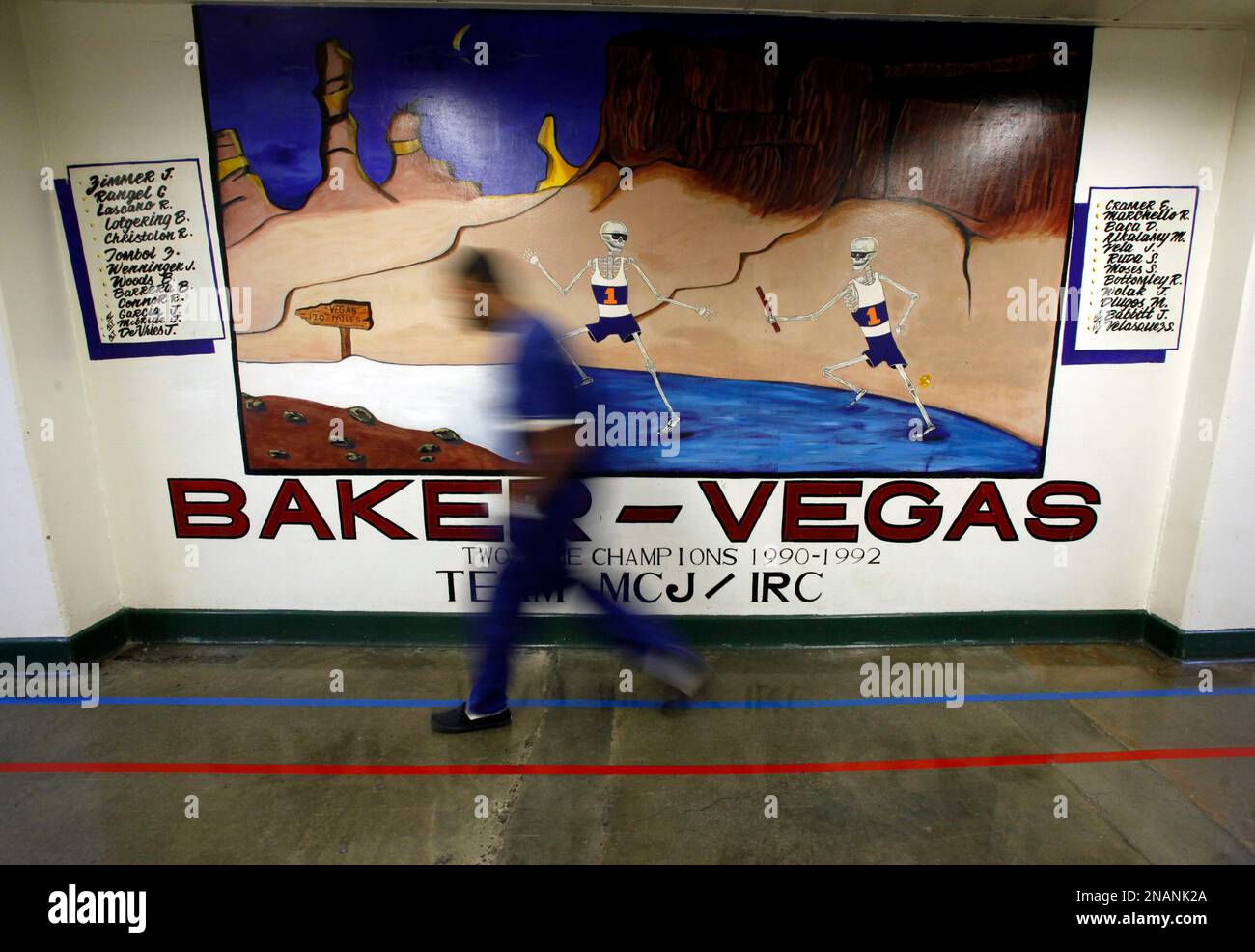 An inmate passes a mural painted by inmates, as are dozens of other