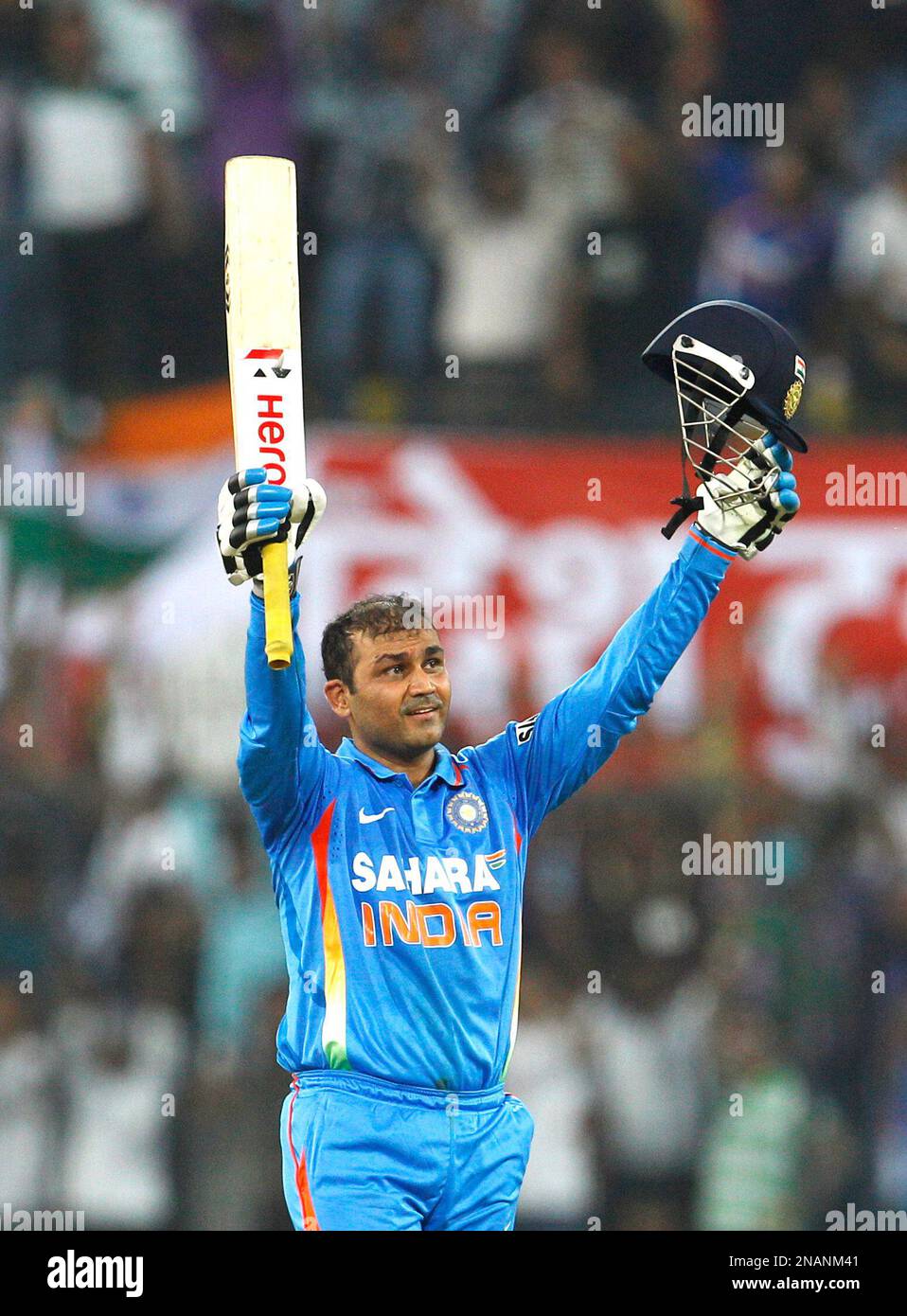 Indias captain Virender Sehwag celebrates scoring double century and his world record one-day score during their fourth one day international cricket match against West Indies in Indore, India, Thursday, Dec