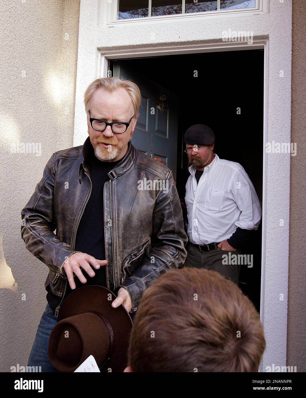 Mythbusters" stars Adam Savage, left, and Jamie Hyneman walk past a child  seeking autographs as they exit the home damaged by an errant cannonball  fired during a filming of an episode of