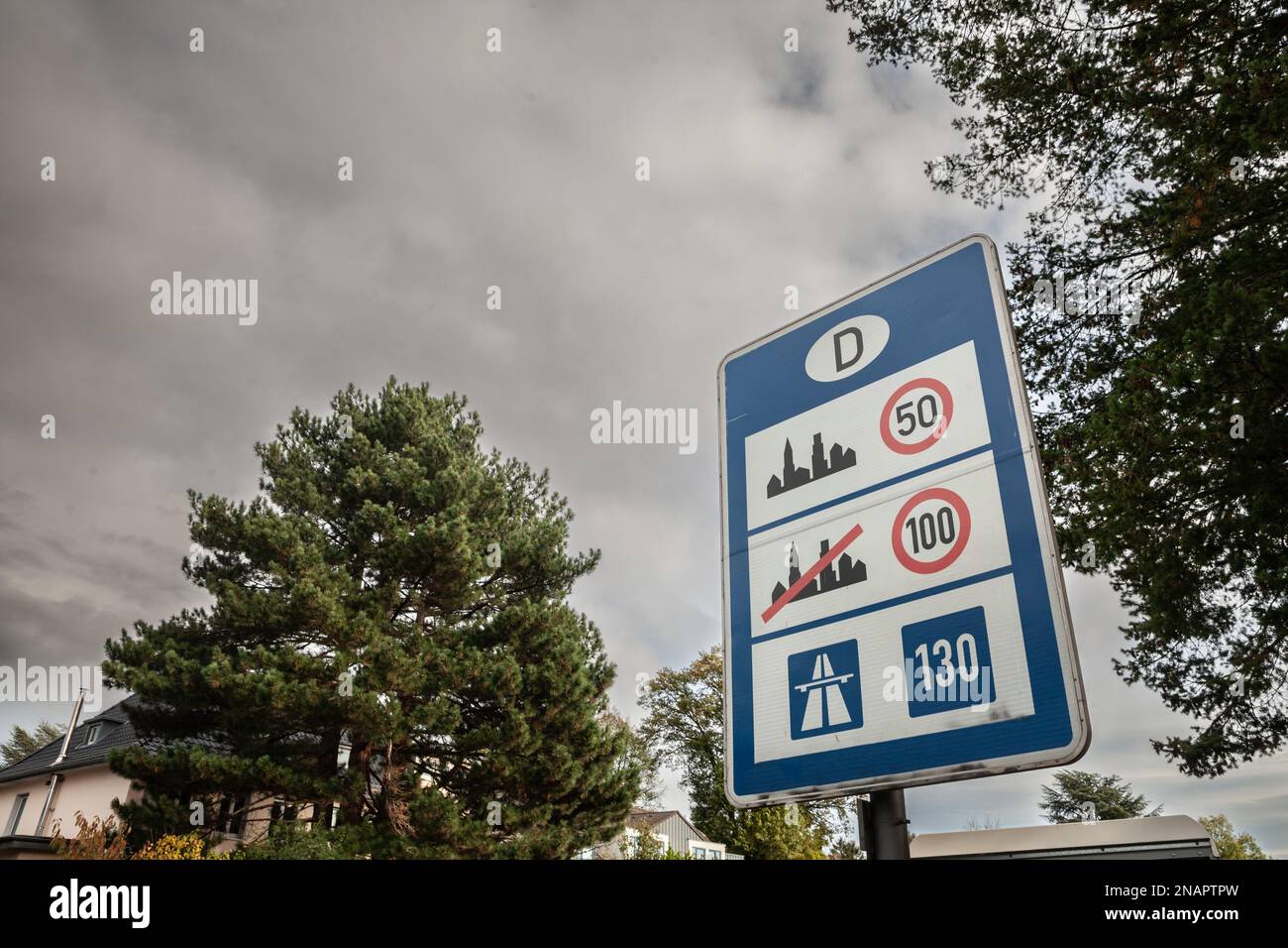 Picture of a road sign indicating the various speed limits applicable by law in Germany, taken on a road at the German border. Stock Photo