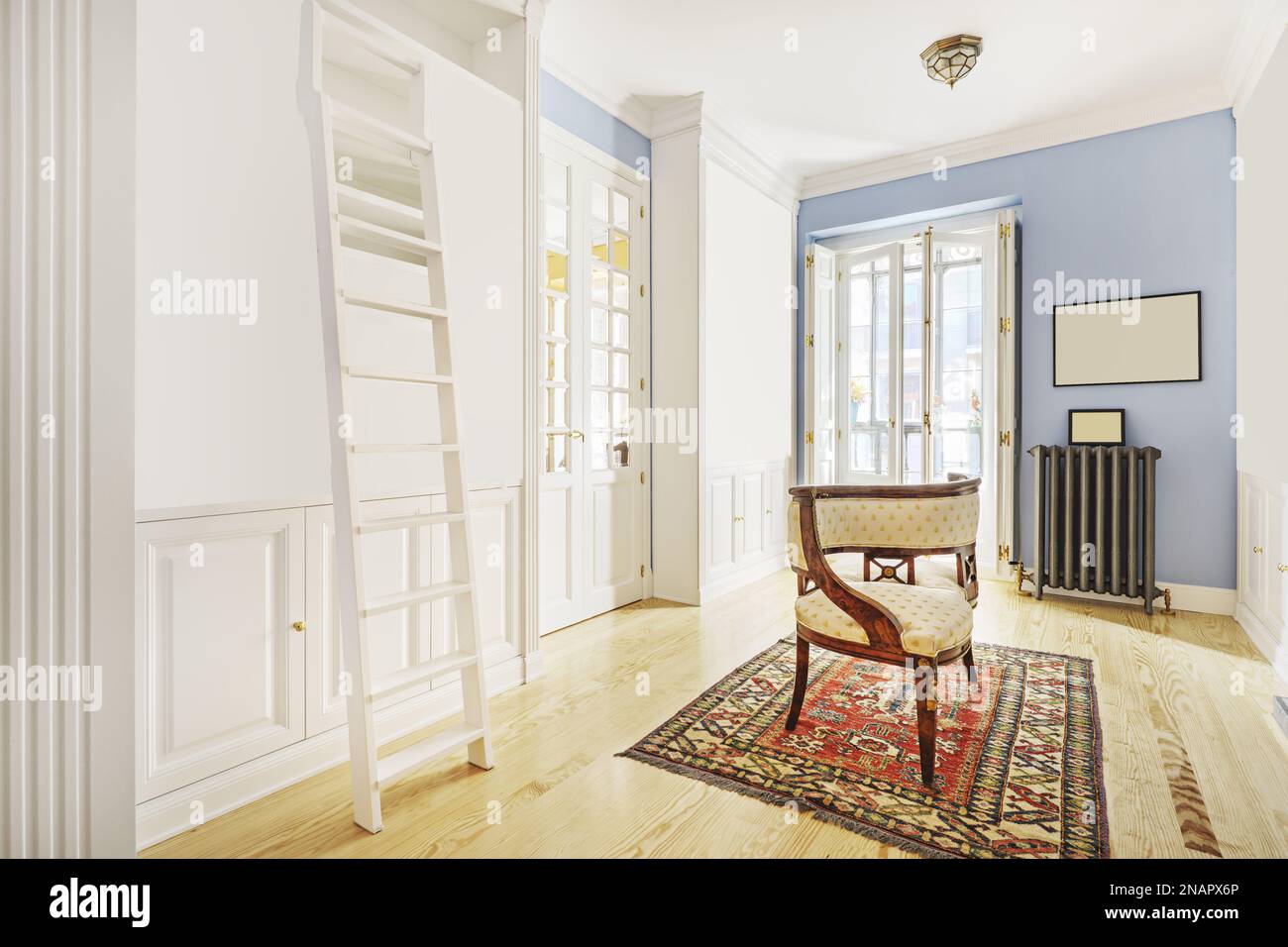 Living room of a house with antique furniture, Persian rugs, white bookcase with stairs and