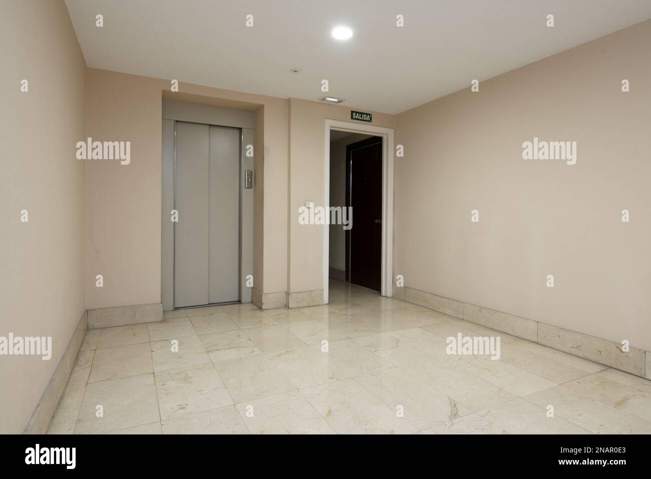 Interior of a residential housing portal with elevator with gray metal doors and polished cream marble floors Stock Photo