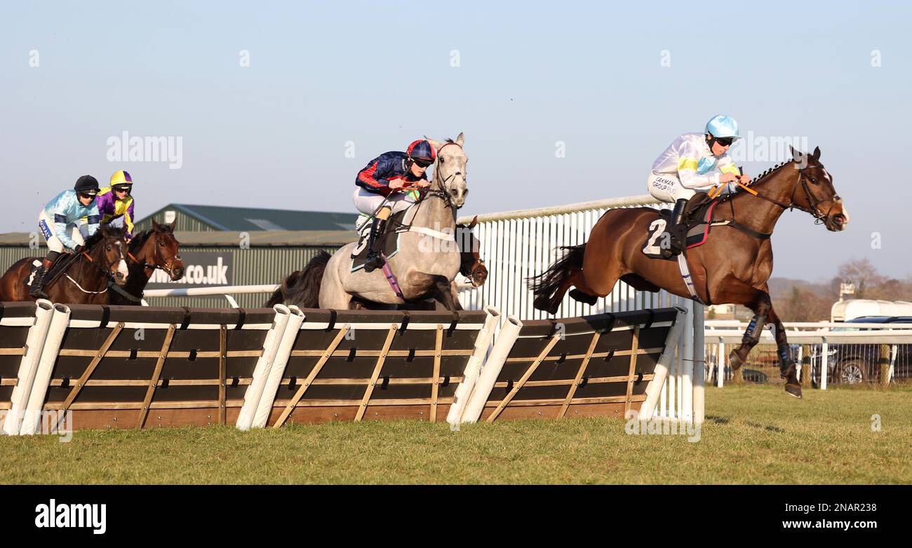 Plumpton, UK. 13th Feb, 2023. Thirtyfourstitches ridden by Charlie Hammond (R) clear an early hurdle before winning the Placesetting Equipment Hire Handicap Hurdle at Plumpton Racecourse. Credit: James Boardman/Alamy Live News Stock Photo