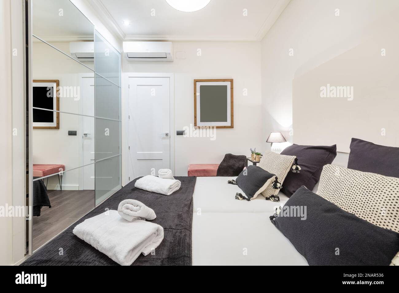 Bedroom with single beds pushed together, many chiens, clean towels and