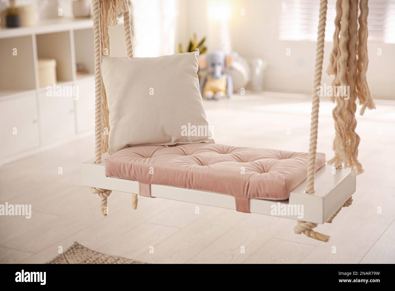 Beautiful swing with pillow in room. Stylish interior design Stock ...