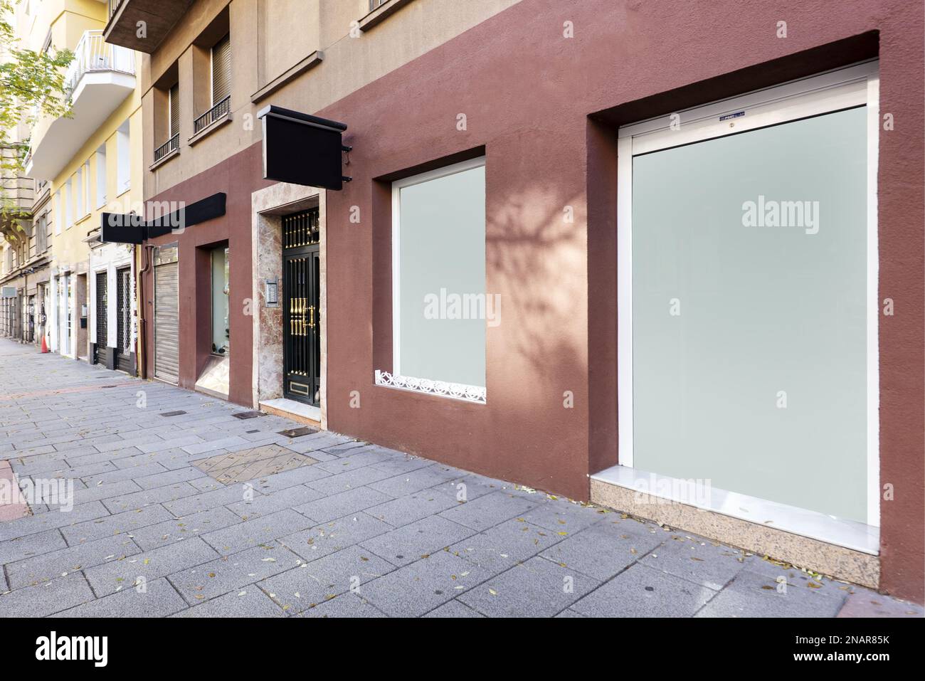 Shop fronts at street level with earth red painted walls and opaque glass surfaces Stock Photo